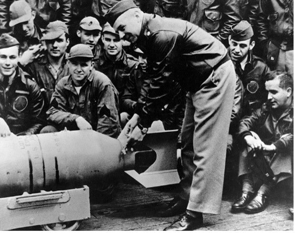 A photo of General Doolittle wiring a Japanese medal to a bomb prior to a raid on Japan