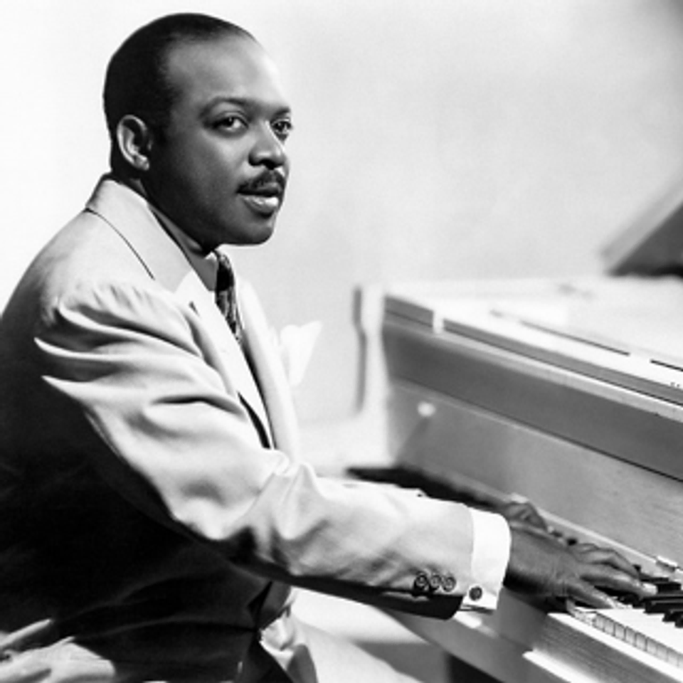 A portrait of Count Basie at his piano.