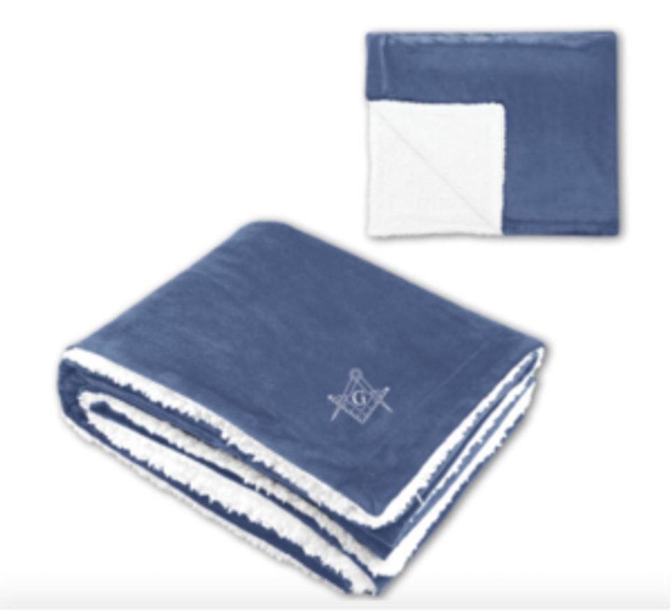 A blue and white sherpa fleece throw blanket embroidered with the Masonic square and compasses symbol, available at The Masonic Marketplace