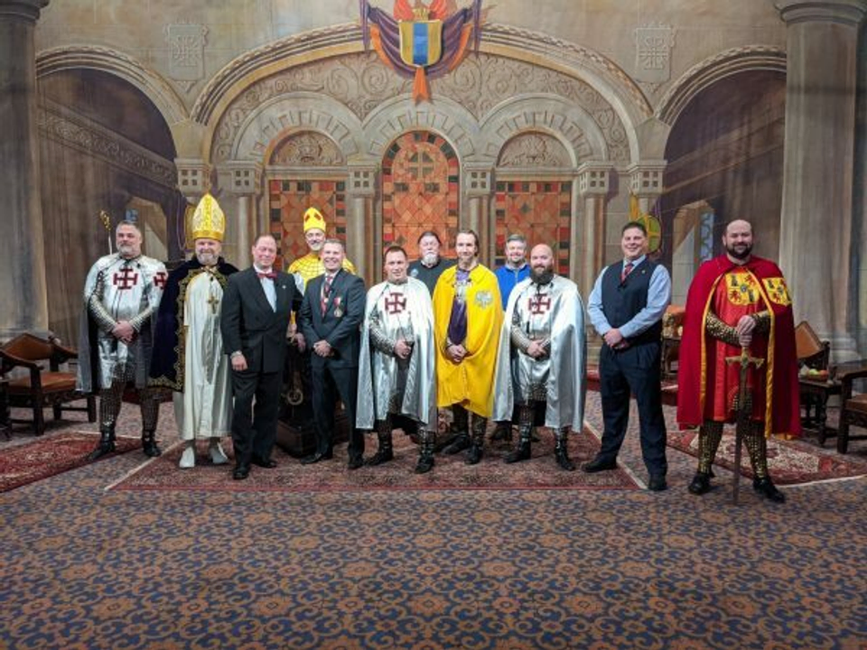 A cast of Scottish Rite Masons poses in front of their production set.